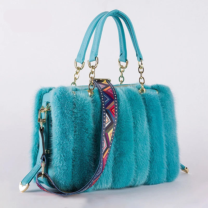 Teal fur handbag with a colorful strap on a light gray background, featuring the brand 'QIMING'.
