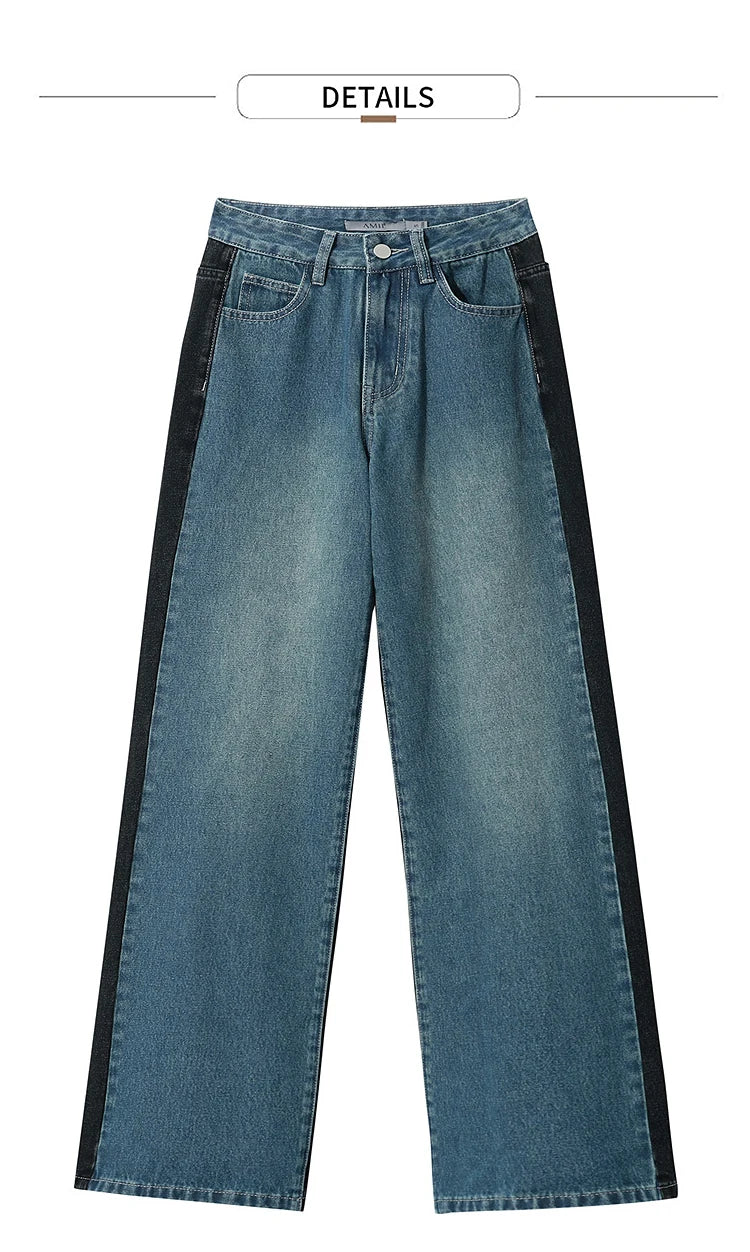 Blue jeans with black side panels on a white background