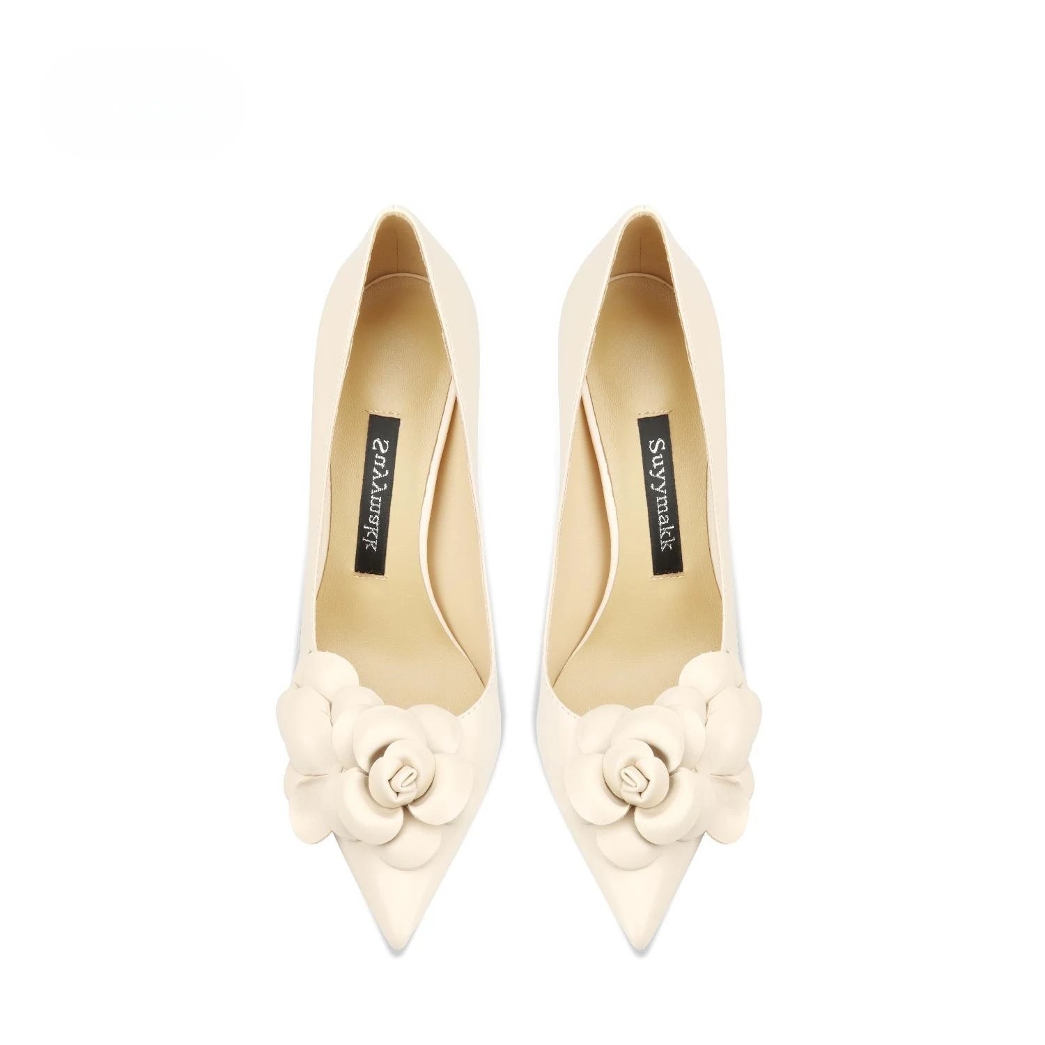 Pair of cream high-heeled shoes with floral details on a white background