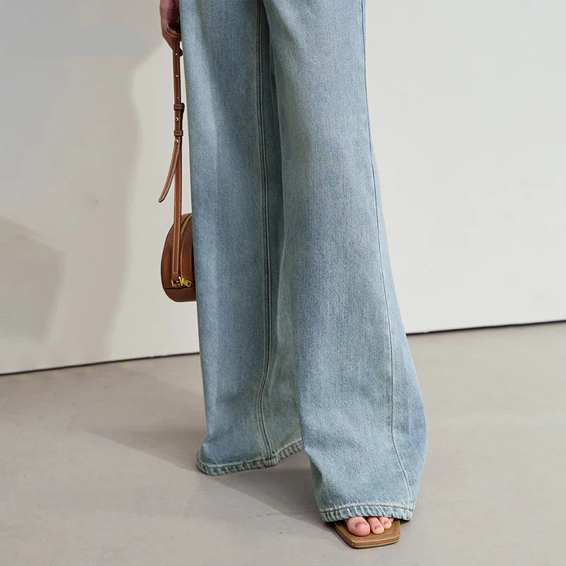 Person wearing light blue jeans with a neutral background