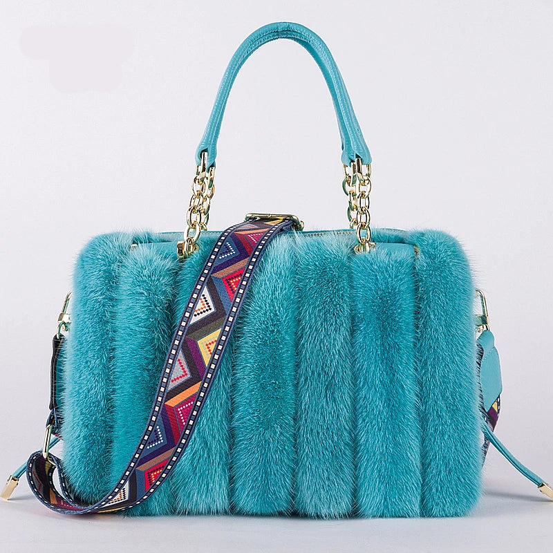 Blue fur handbag with a colorful strap on a light gray background, featuring the brand 'QIMING'.