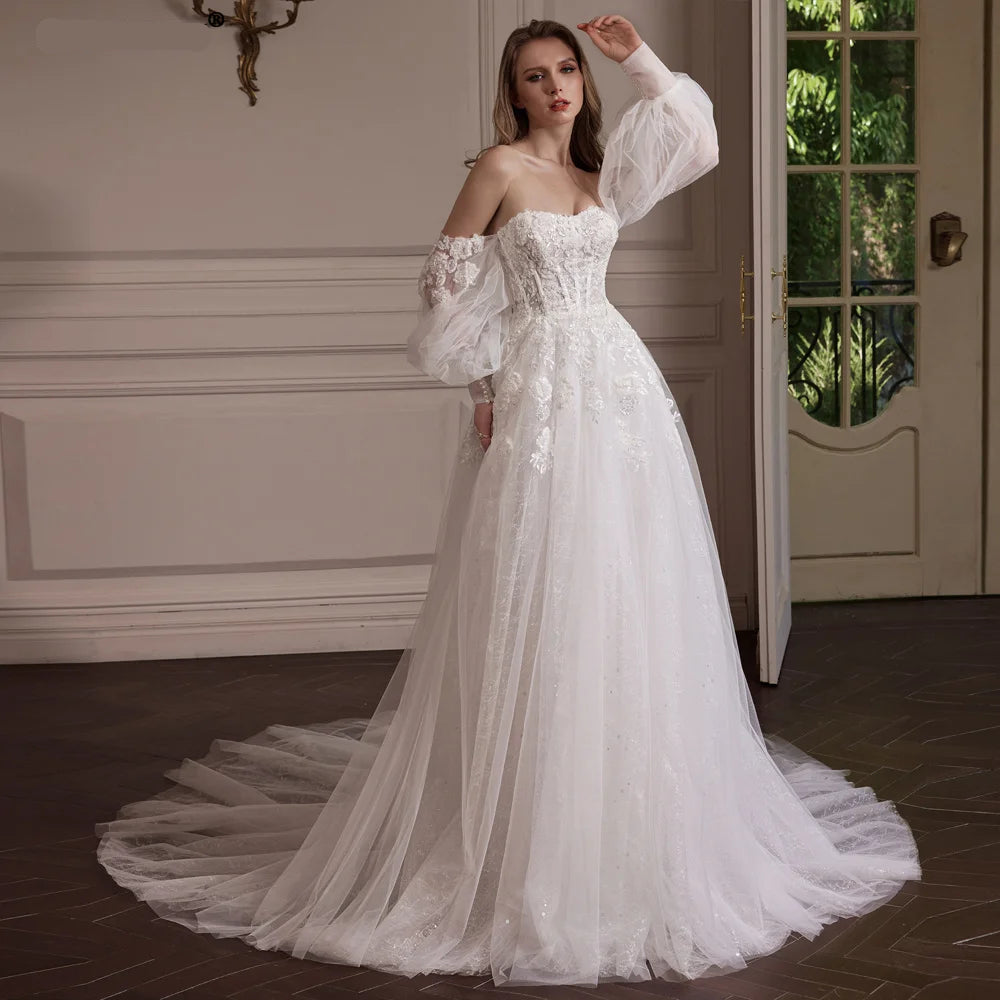 Woman wearing a white wedding dress with long train indoors.