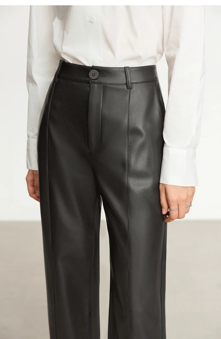 Person wearing black wide-leg pants and a white shirt on a gray background with 'Amii' branding.