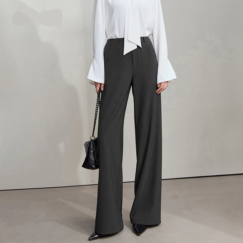 Person wearing a white shirt and black wide-leg pants with a handbag, standing against a plain background. - HER SHOP