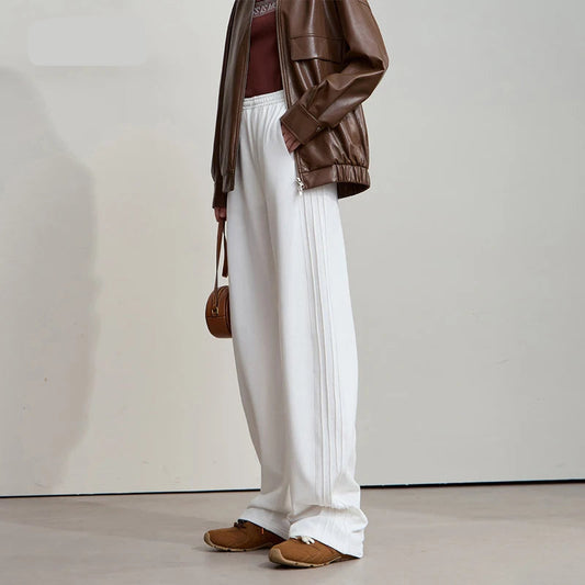 Person wearing brown outfit with wide-leg pants and holding a bag, standing against a plain background. - HER SHOP