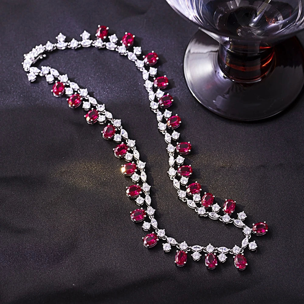 Necklace with red and clear gemstones on a dark fabric background