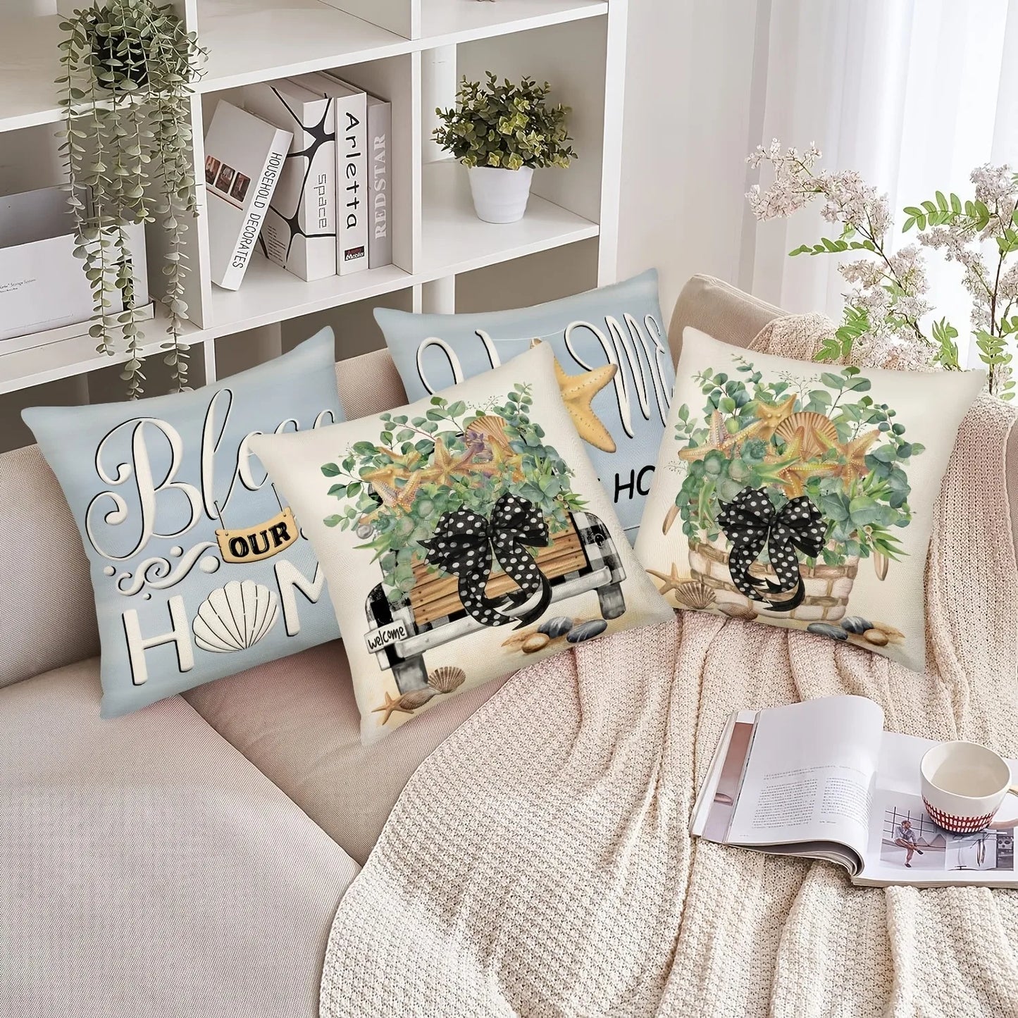 Decorative pillows with floral and text designs on a sofa with a book and mug.