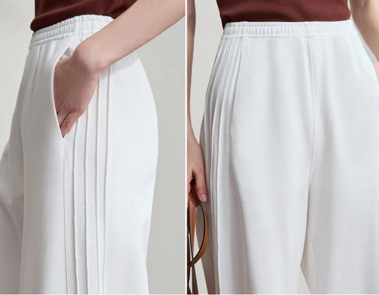 White pants worn by a person with a neutral background, featuring the brand 'AMII'.