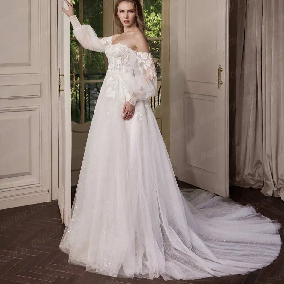 Woman in a white wedding dress standing in a room with wooden floor and beige walls.