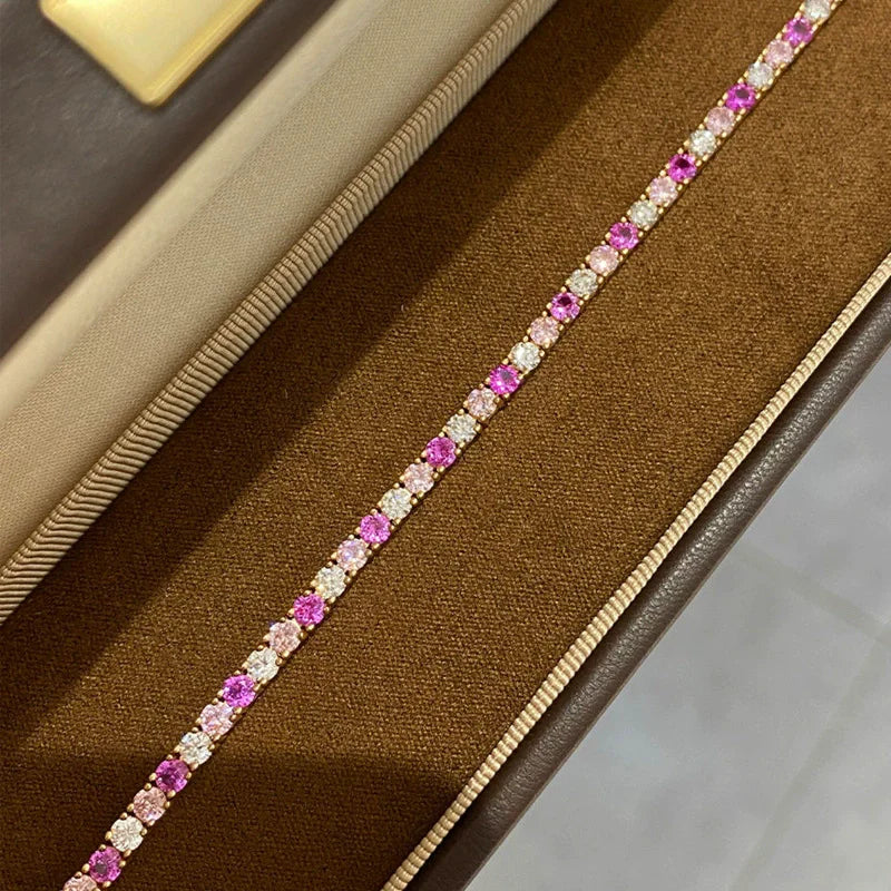 Gold bracelet with pink and White stones on a White background, featuring the wuha brand.