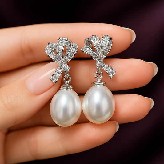 Bride wearing a tiara, veil, and pearl earrings against a neutral background - HER SHOP