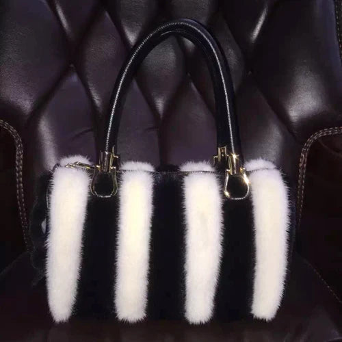 White fur handbag with brown handles on a stand, branded 'LLHPB FUR'.