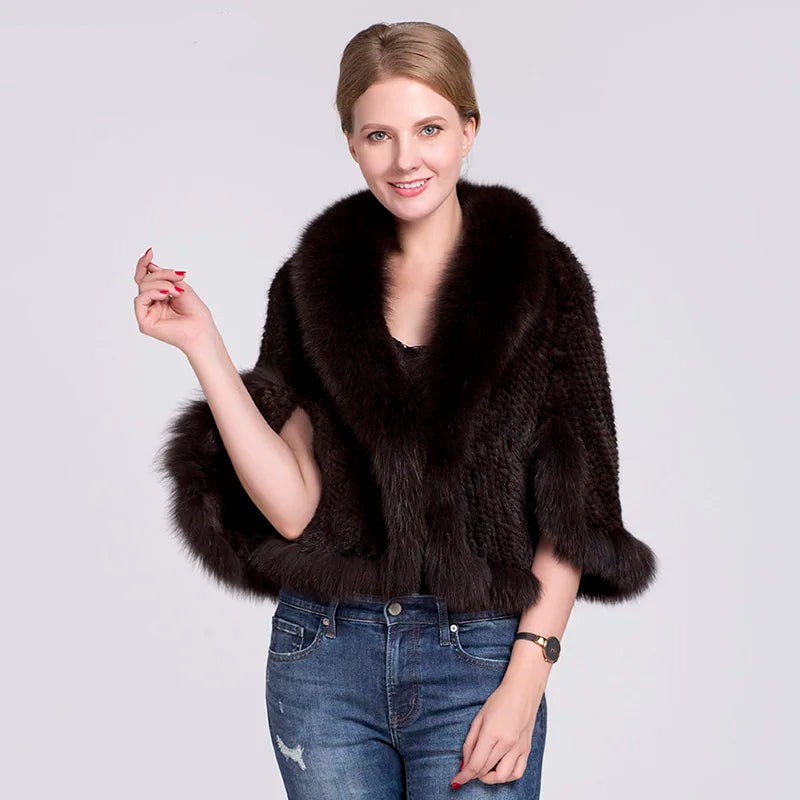 Woman wearing a dark brown fur vest over a black top with blue jeans on a white background.
