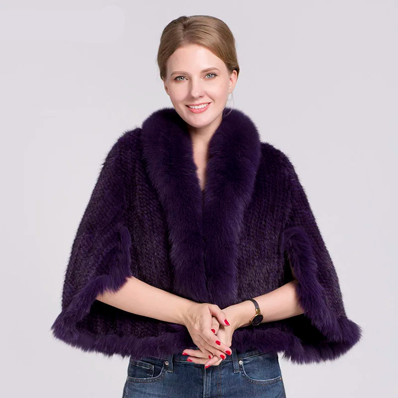 Woman wearing a dark purple fur poncho with a white background