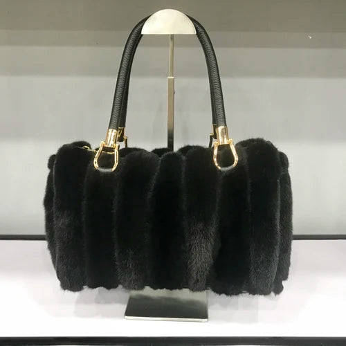 White fur handbag with brown handles on a stand, branded 'LLHPB FUR'.