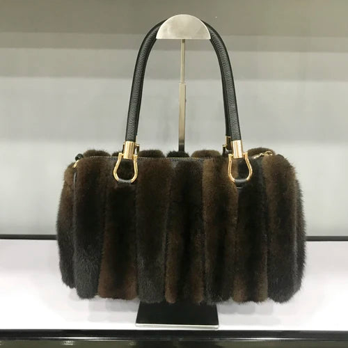 White fur handbag with brown handles on a stand, branded 'LLHPB FUR'.