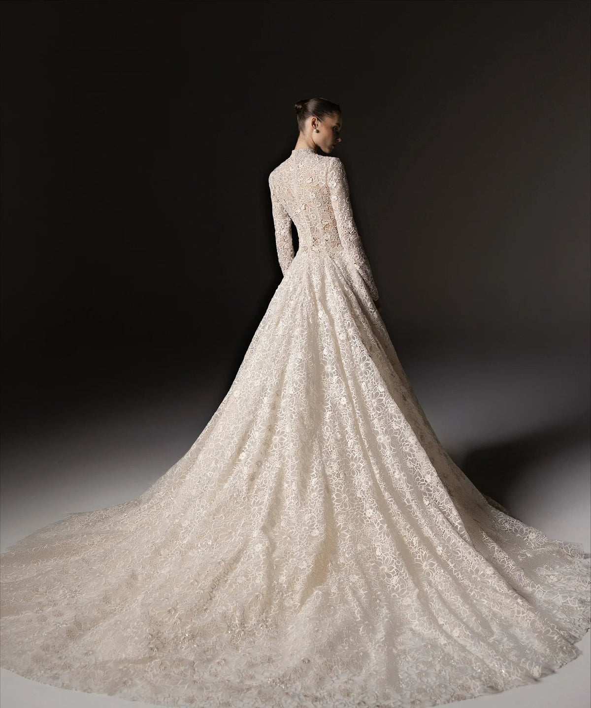 A model shown from the back wearing a long-sleeved lace modest wedding gown with a full train, photographed against a dark studio background. The text 'LISM Dresses Store' is visible at the bottom.