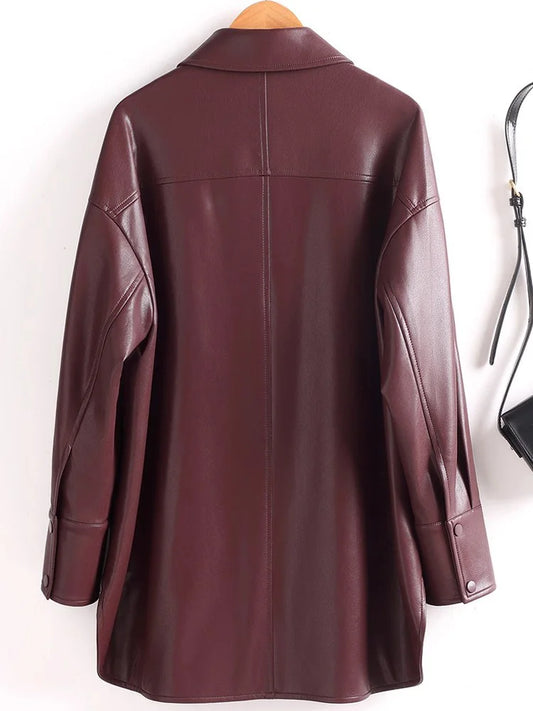 Brown leather shirt on a hanger with a handbag in the background - HER SHOP