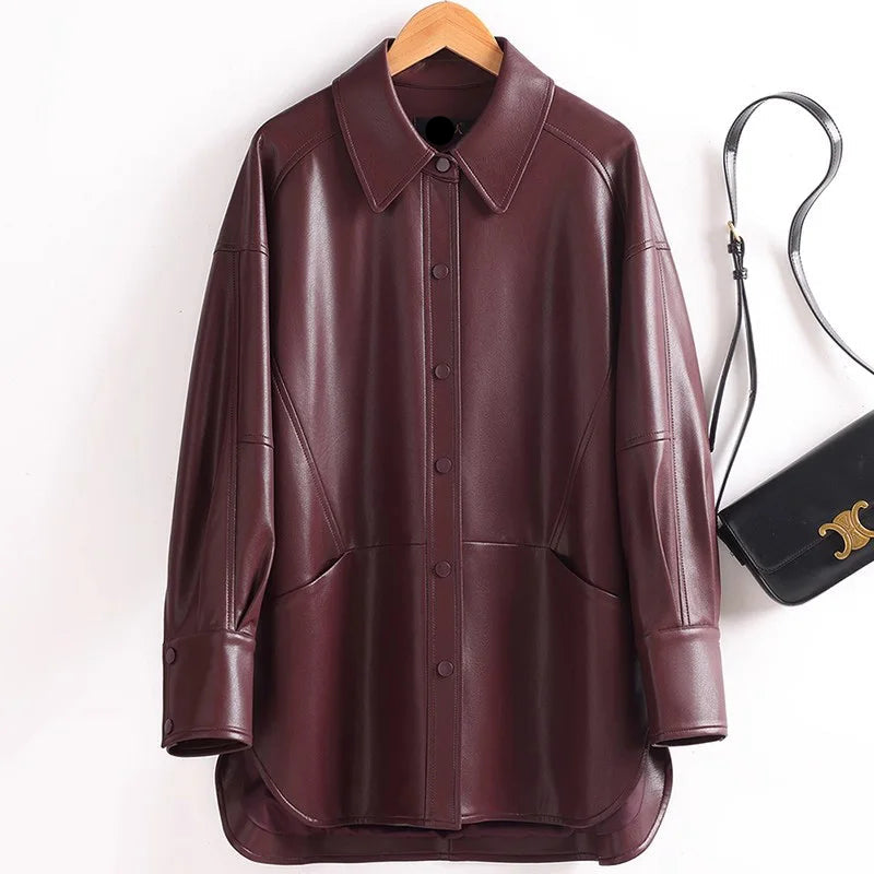 Brown leather shirt on a hanger with a handbag in the background