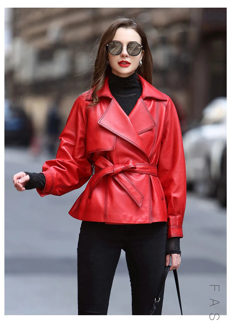 Woman wearing a red leather jacket and black pants on a blurred street background