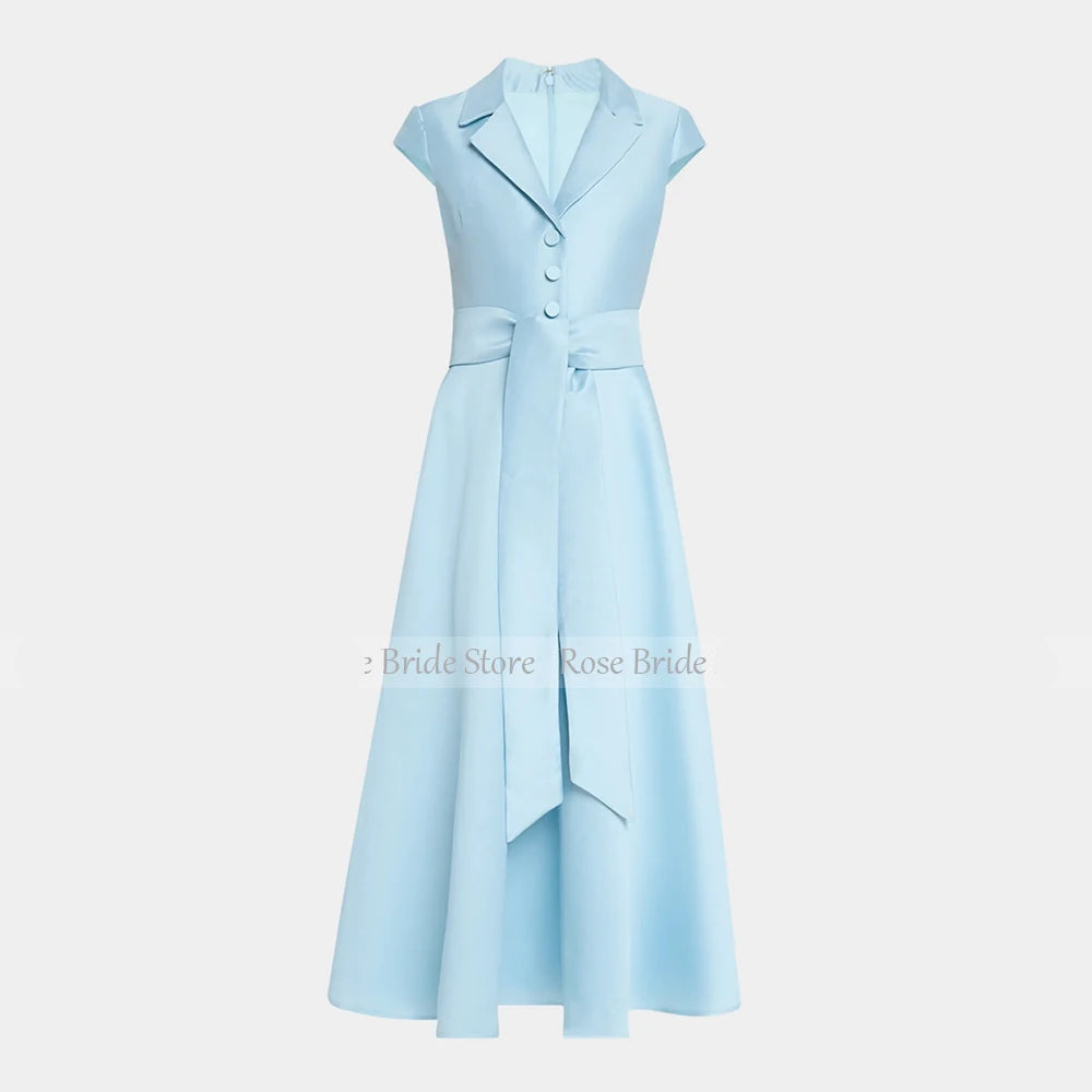 A light blue sleeveless midi dress with a structured collar, front buttons, a defined waist, and a draped asymmetrical skirt detail, shown on a plain light gray background.