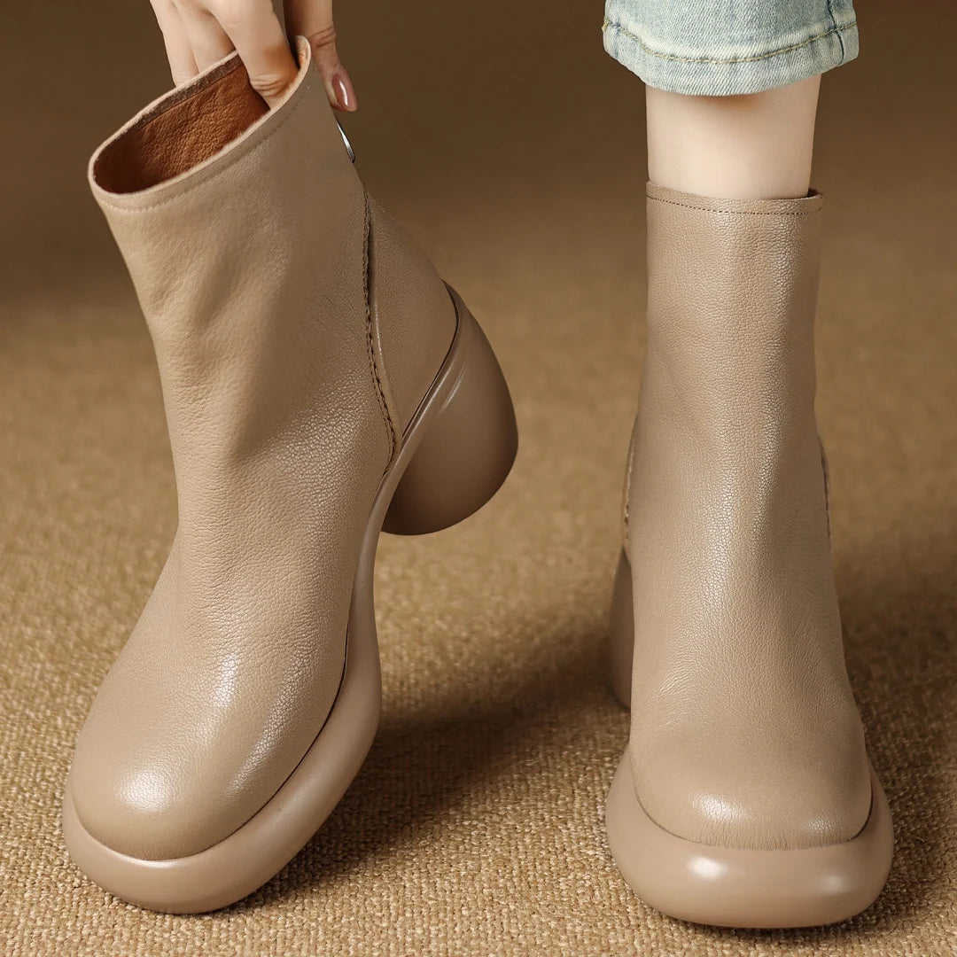 Beige ankle boots on a textured brown surface
