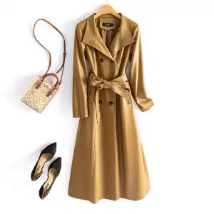 Green leather coat with a brown handbag and black shoes on a white background
