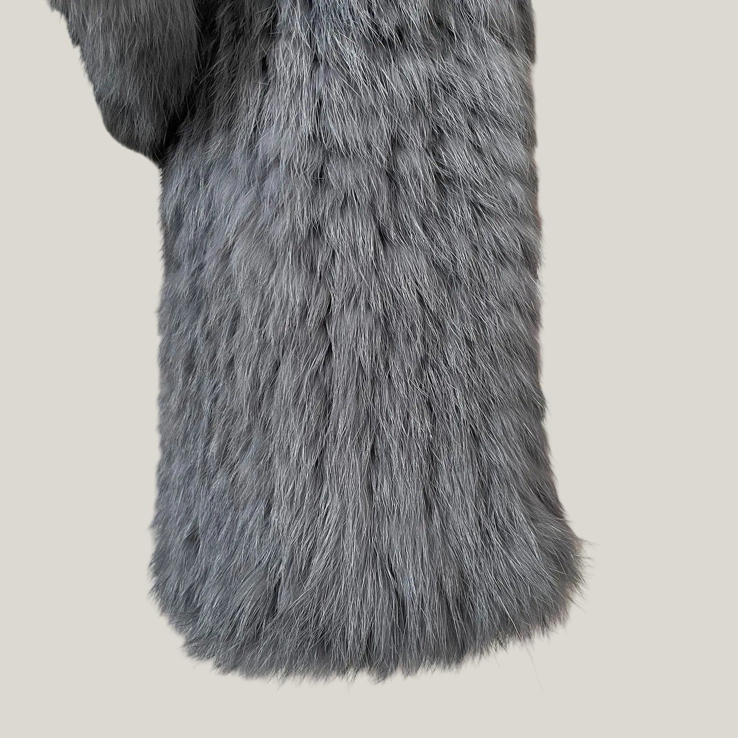 Close-up of a gray fur coat with a striped background