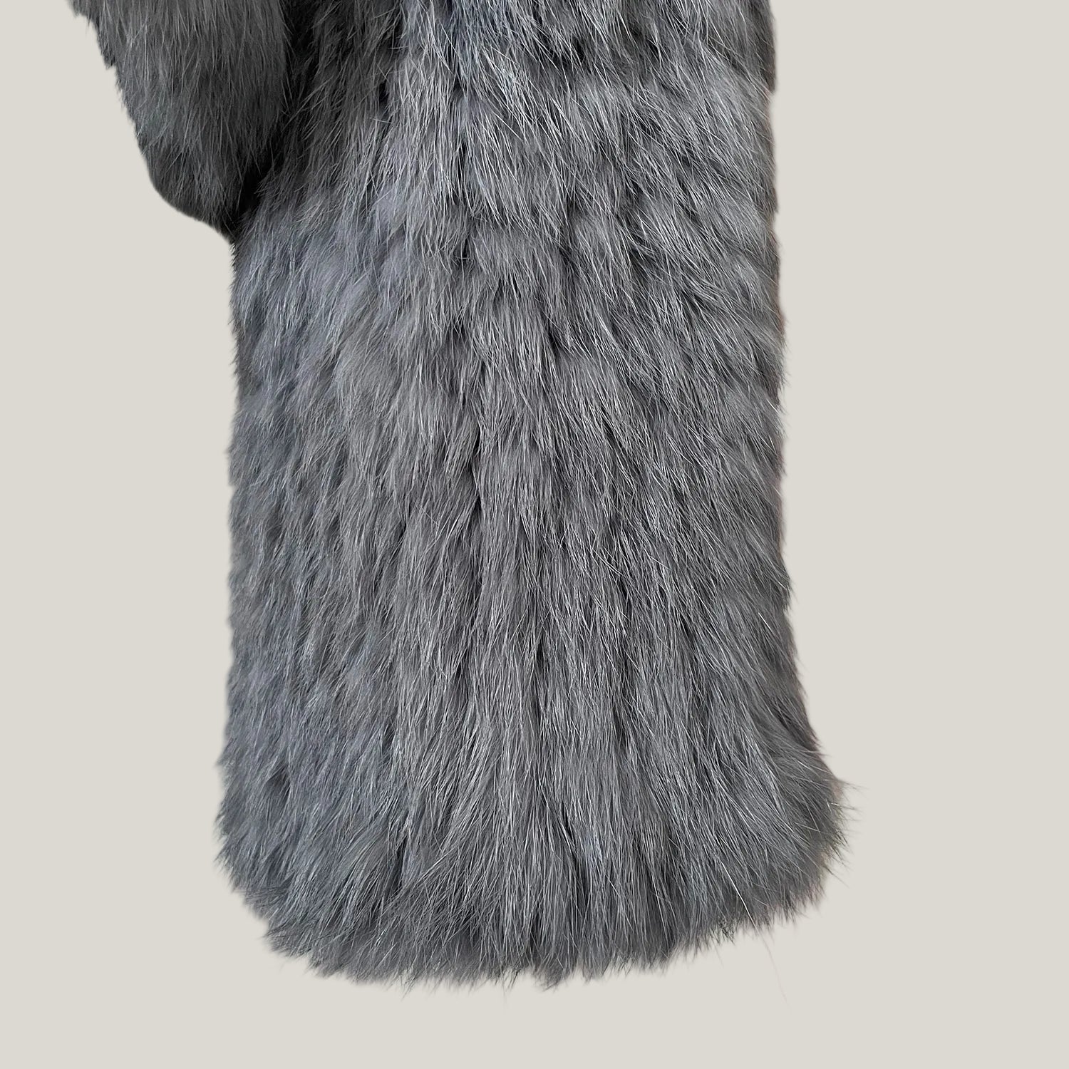 Close-up of a gray fur coat with a striped background