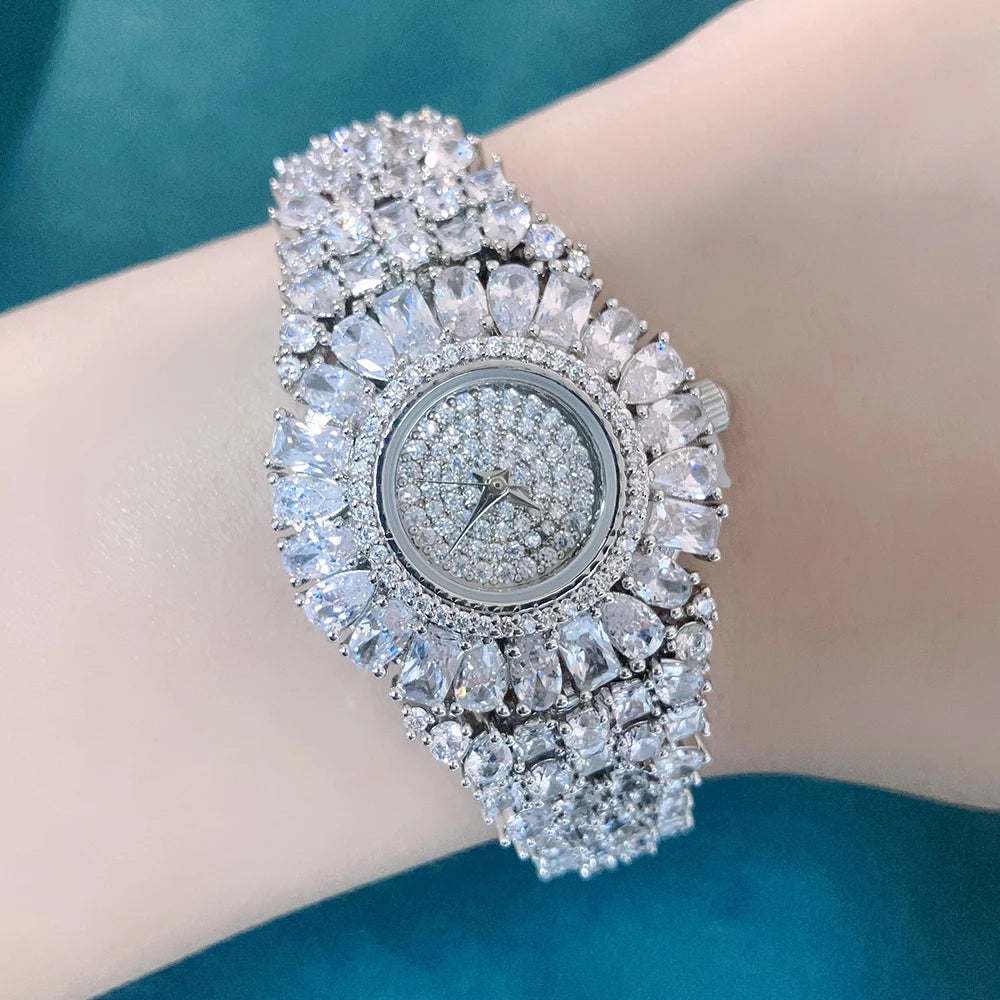 Luxury diamond-encrusted watch on a wrist against a teal background