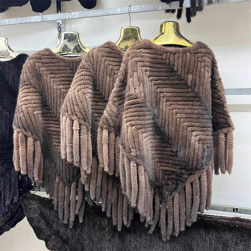 Three brown textured sweaters hanging on a rack.