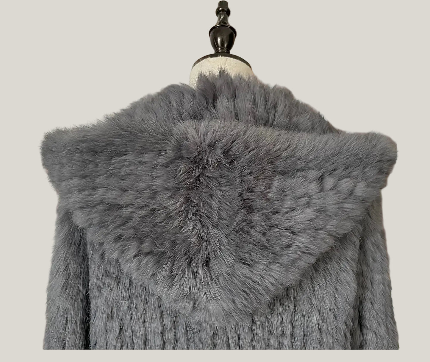 Gray fur vest on a hanger with a decorative background