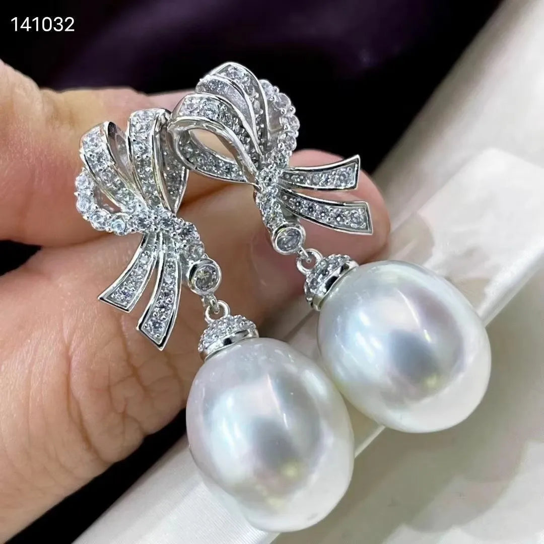 Bride wearing a tiara, veil, and pearl earrings against a neutral background