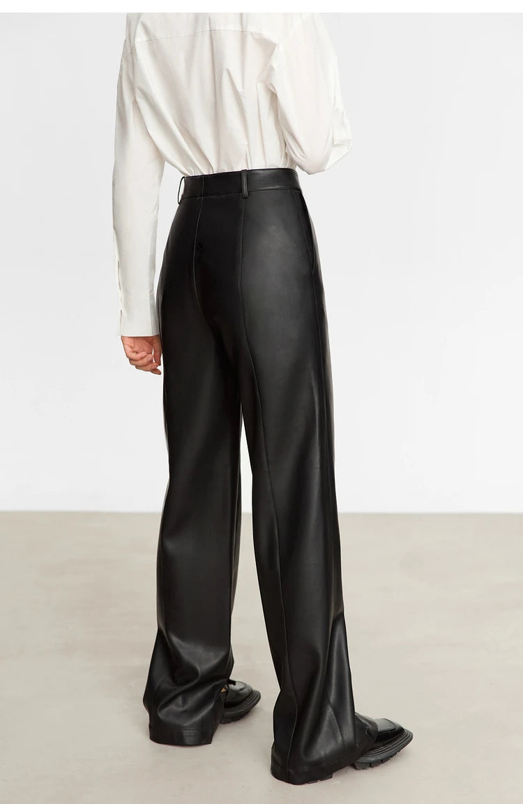 Person wearing black wide-leg pants and a white shirt on a gray background with 'Amii' branding.