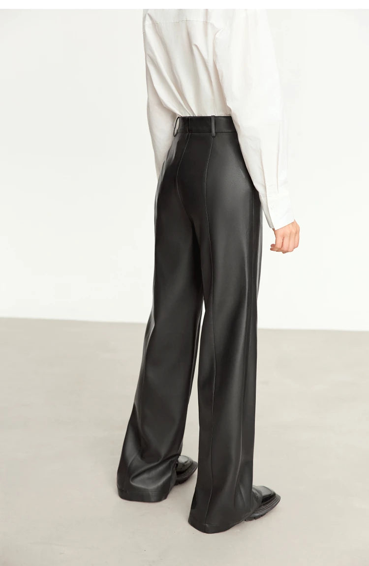 Person wearing black wide-leg pants and a white shirt on a gray background with 'Amii' branding.