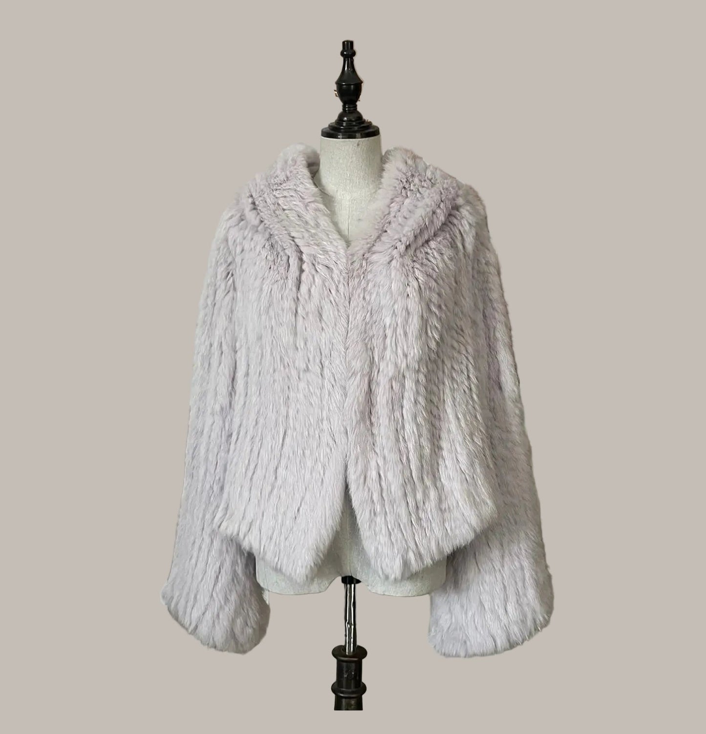 White fur coat on a mannequin against a plain background