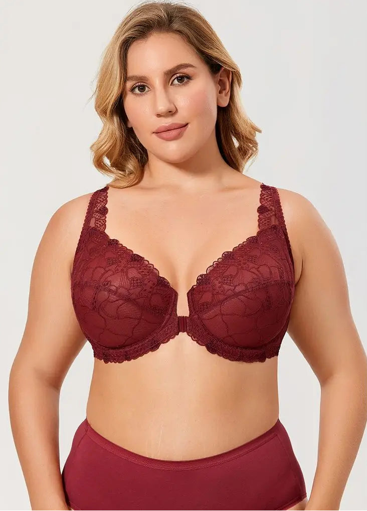 Woman wearing a red lace bra and underwear set on a plain background