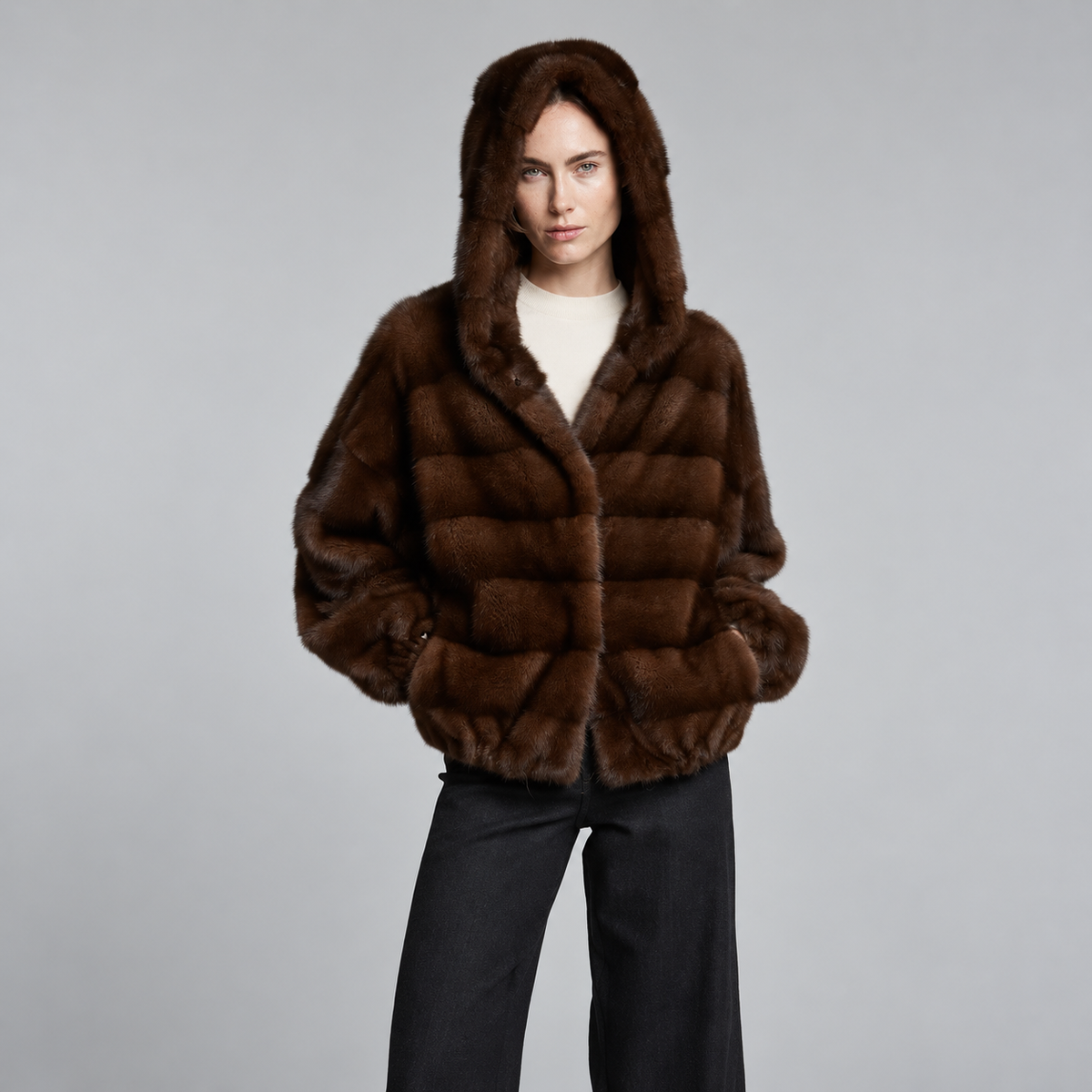 Women’s mahogany brown mink fur coat with hood down and horizontal fur panels.